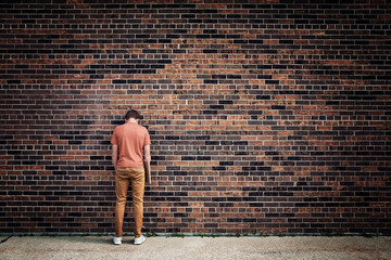Fototapeta na wymiar Student blending into brick wall