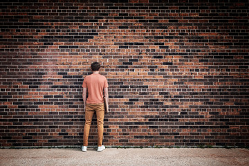 Student blending into brick wall