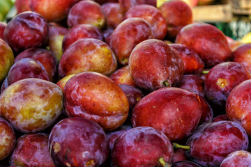 organic plum fruit on the farm market. Ripe juicy plums as background