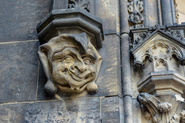 The face of a stone gargoyle in the form of a jester