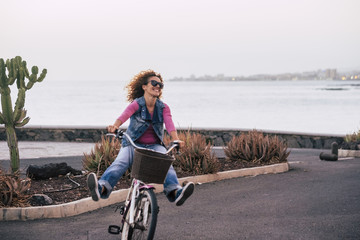 Fototapeta na wymiar happiness and joyful for curly beautiful lady go on a bybicle opening legs and having a lot of fun. freedom and enjoying life concept with cheerful people in outdoor leisure activity.