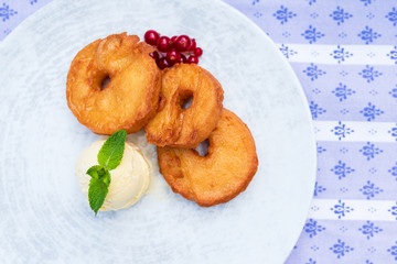 gebackene frittierte Apfelküchle Dessert im Biermantel Teig mit Vanille Eis und Preiselbeeren im Biergarten Oktoberfest serviert 