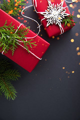 Christmas handmade red gift boxes on dark grey background top view. Merry christmas greeting card. Winter xmas holiday theme. Happy New Year. Flat lay.