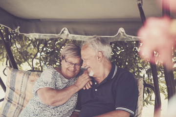 nice couple of beautiful caucasian senior 70 years old sit outdoor at home having fun with smiles...