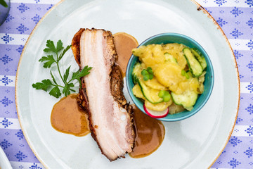 Bayerischer Schweinebraten vom Schweine Bauch und Kartoffelsalat mit Gurken  und Sauce Oktoberfest