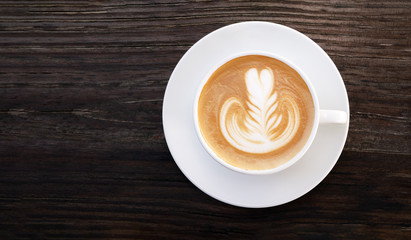 Hot coffee cappuccino latte art top view on dark wooden background