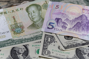 Obraz na płótnie Canvas Banknote of five Chinese yuan against background of american dollars