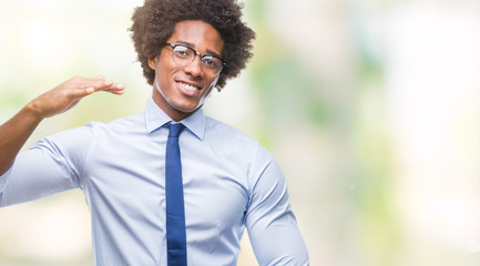 Afro american business man wearing glasses over isolated background gesturing with hands showing big and large size sign, measure symbol. Smiling looking at the camera. Measuring concept.