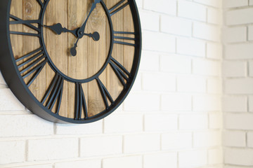 Clock hanging on brick wallpaper