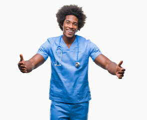 Afro american surgeon doctor man over isolated background looking at the camera smiling with open arms for hug. Cheerful expression embracing happiness.