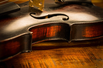 Old violin in vintage style on wood background