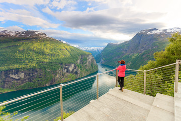 Fototapeta na wymiar Tourist taking photo from Flydasjuvet viewpoint Norway