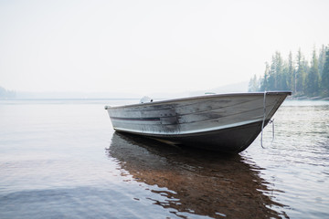 Naklejka premium Metal motor boat on the Cultus lake in south Oregon. Haze from burning fires on the horizon.