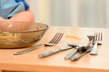Little caucasian boy eats soup with his hands