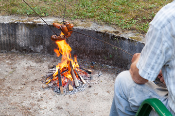 Grilled sausages above the campfire