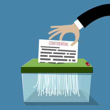 Hand putting paper in shredder: Confidential document termination