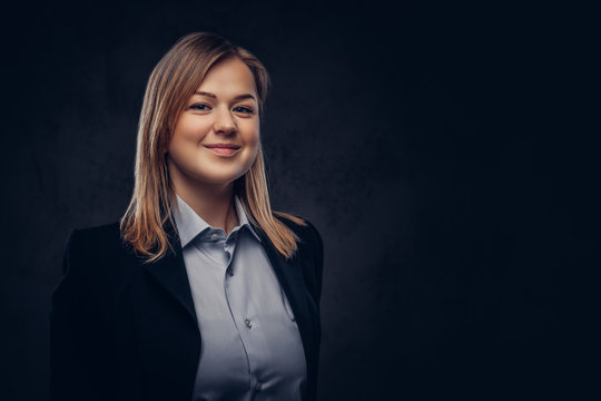 Portrait Of A Smiling Blonde Businesswoman Formal Dressed. Isolated On Dark Textured Background.