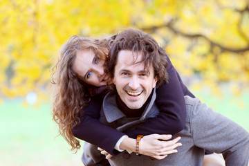 Smiling couple play in autumn forest