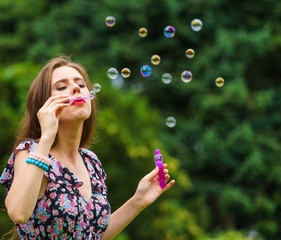 Woman blowing soap bubbles, having fun