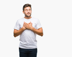 Young handsome man over isolated background smiling with hands on chest with closed eyes and...
