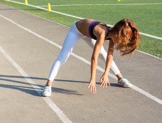 A teenage is warming up before running in the stadium