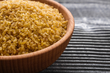 raw bulgur on a rustic wooden background