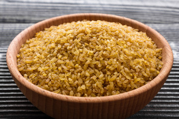 raw bulgur on a rustic wooden background