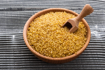 raw bulgur on a rustic wooden background