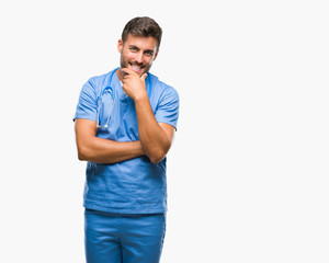 Young handsome doctor surgeon man over isolated background looking confident at the camera with smile with crossed arms and hand raised on chin. Thinking positive.