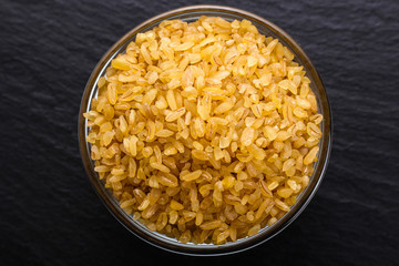 raw bulgur on a dark stone background