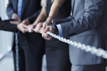 Businessmen pulling chain