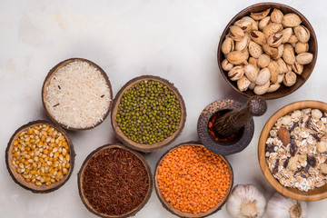 Fototapeta na wymiar cereals, seeds, beans, grains in a bowls on white table, top view