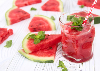 Watermelon lemonade on a wooden table with colorful drinking straws.