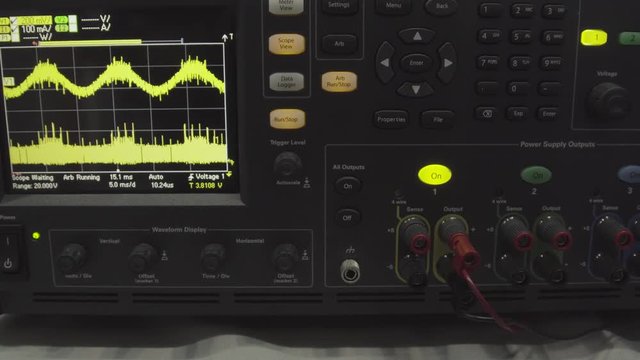 Fragment of a modern digital oscilloscope. Scientific measuring equipment. Abstract industrial background. Digital oscilloscope is used by an experienced electronic engineer in the laboratory. Wave on