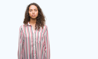 Beautiful young hispanic woman with serious expression on face. Simple and natural looking at the camera.