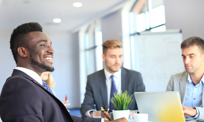 Business people in discussing something while sitting together at the table.