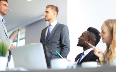 Business people in discussing something while sitting together at the table.