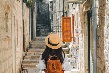 woman walking by kotor city in sunny day - obrazy, fototapety, plakaty