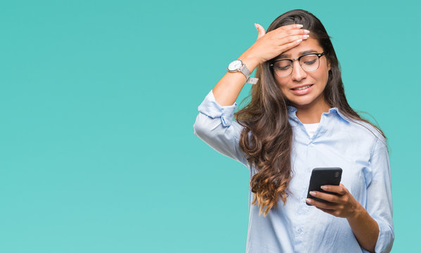 Young Beautiful Arab Woman Texting Using Smartphone Over Isolated Background Stressed With Hand On Head, Shocked With Shame And Surprise Face, Angry And Frustrated. Fear And Upset For Mistake.