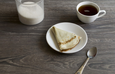 pancakes on a plate lying on the table with tea