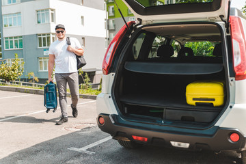 man putting bags in car trunk. ready for car travel