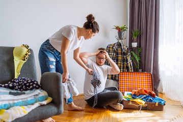 woman bring more stuff to overloaded bag. travel concept.