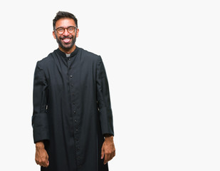 Obraz premium Adult hispanic catholic priest man over isolated background sticking tongue out happy with funny expression. Emotion concept.