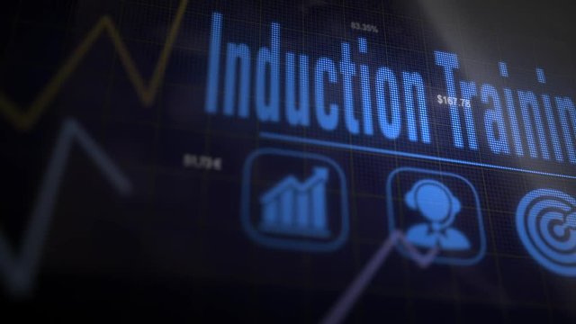 A Induction Training business concept on a flashing computer monitor with moving graphs and data.