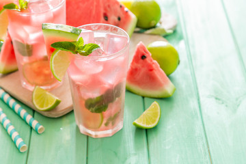 Watermelon lemonade with lime and mint, wood background, copy space