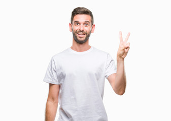 Naklejka premium Young handsome man over isolated background smiling with happy face winking at the camera doing victory sign. Number two.