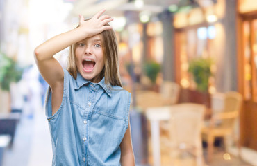 Young beautiful girl over isolated background surprised with hand on head for mistake, remember...