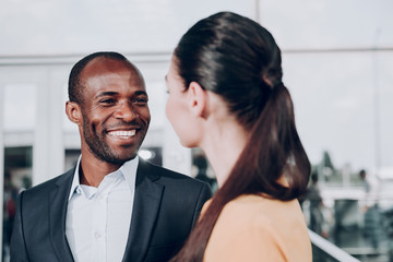 Glad to see you. Close up portrait of two people smiling. Focus on man in jacket looking genuinely...