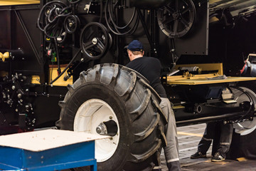 Industrial worker assembles agricultural equipment at plant