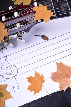 Music autumn composition consisting of guitar fingerboard, dry leaves and musical staff